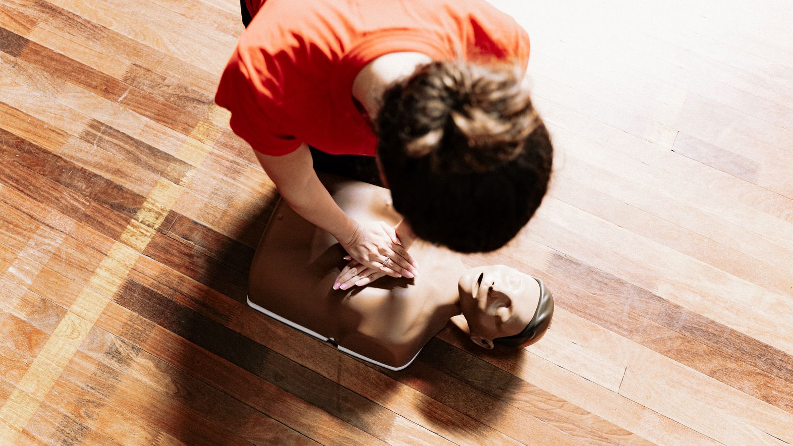 Instructeur doet borstcompressies voor op een reanimatiepop